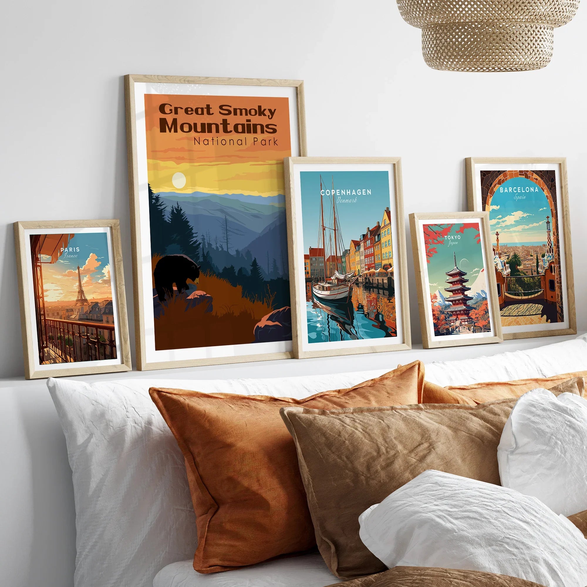 Framed travel art prints of Great Smoky Mountains, Paris, Copenhagen, Tokyo, and Barcelona above bed