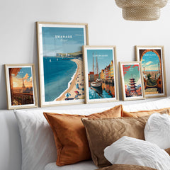Swanage Dorset Wall Art Print | British Seaside Beach Travel Poster displayed on a stylish couch with other travel posters.