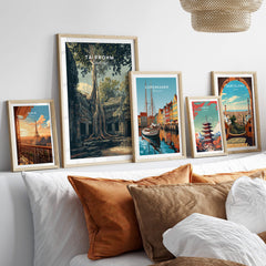 Ta Prohm Cambodia Travel Poster | Ancient Temple Jungle Ruins Wall Art Print displayed among other travel posters on a cozy sofa.