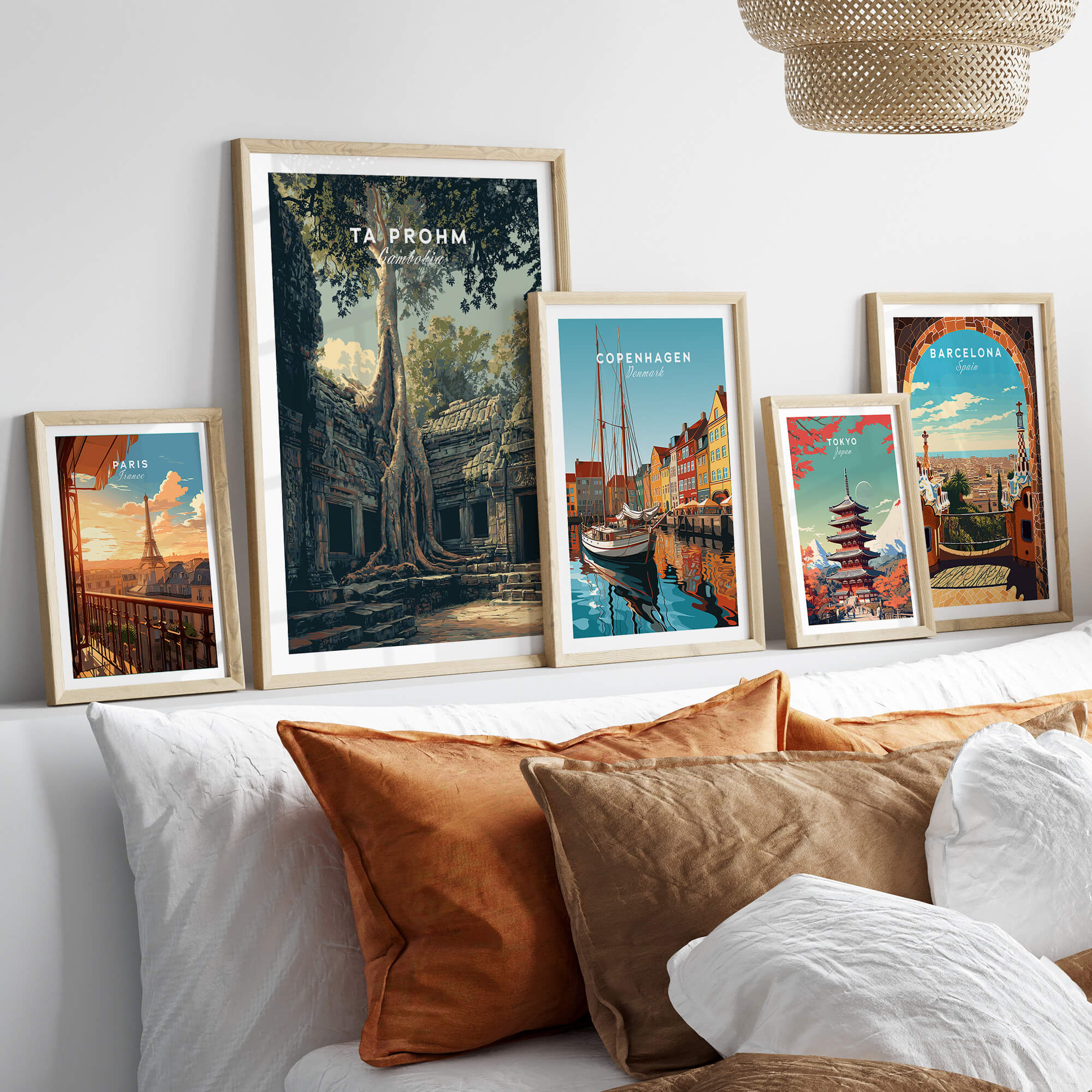 Ta Prohm Cambodia Travel Poster | Ancient Temple Jungle Ruins Wall Art Print displayed among other travel posters on a cozy sofa.