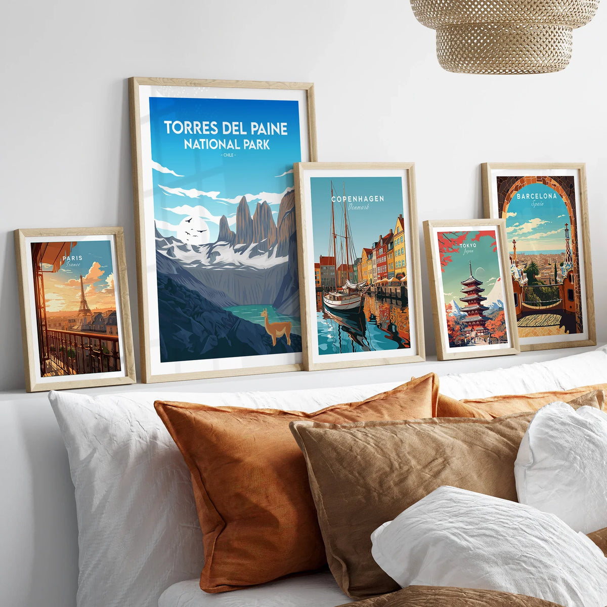 Framed travel posters of famous cities and national park above bed with cozy pillows