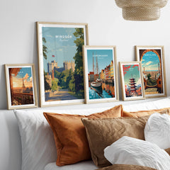 Set of five framed travel art prints above bed, featuring Paris, Windsor, Copenhagen, Tokyo, Barcelona.