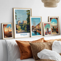 Framed travel posters of Windsor, Paris, Copenhagen, Tokyo, and Barcelona above a bed