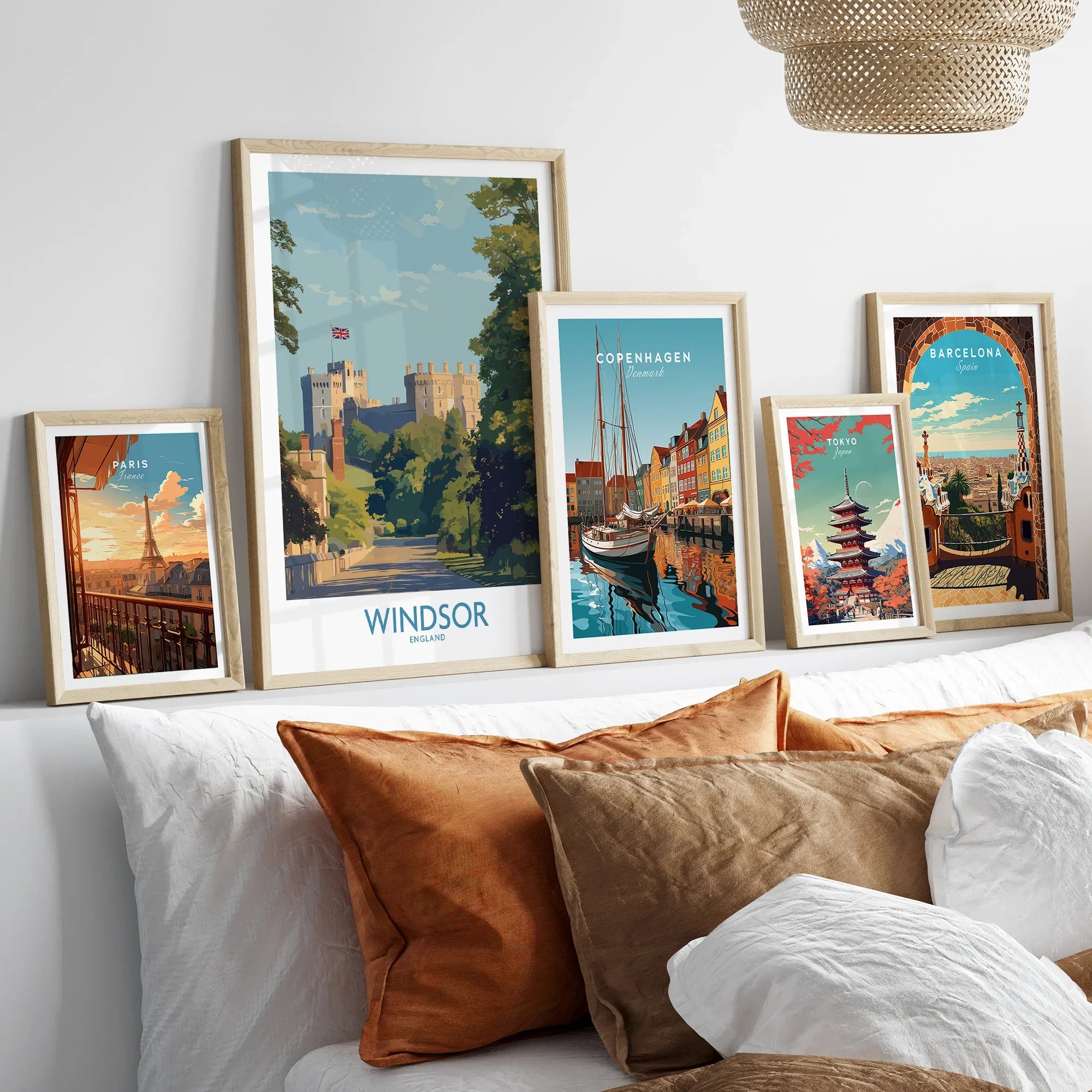 Framed travel posters of Windsor, Paris, Copenhagen, Tokyo, and Barcelona above a bed