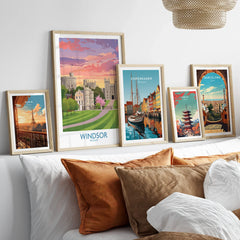 Framed travel posters of Windsor, Paris, Copenhagen, Tokyo, and Barcelona above a bed