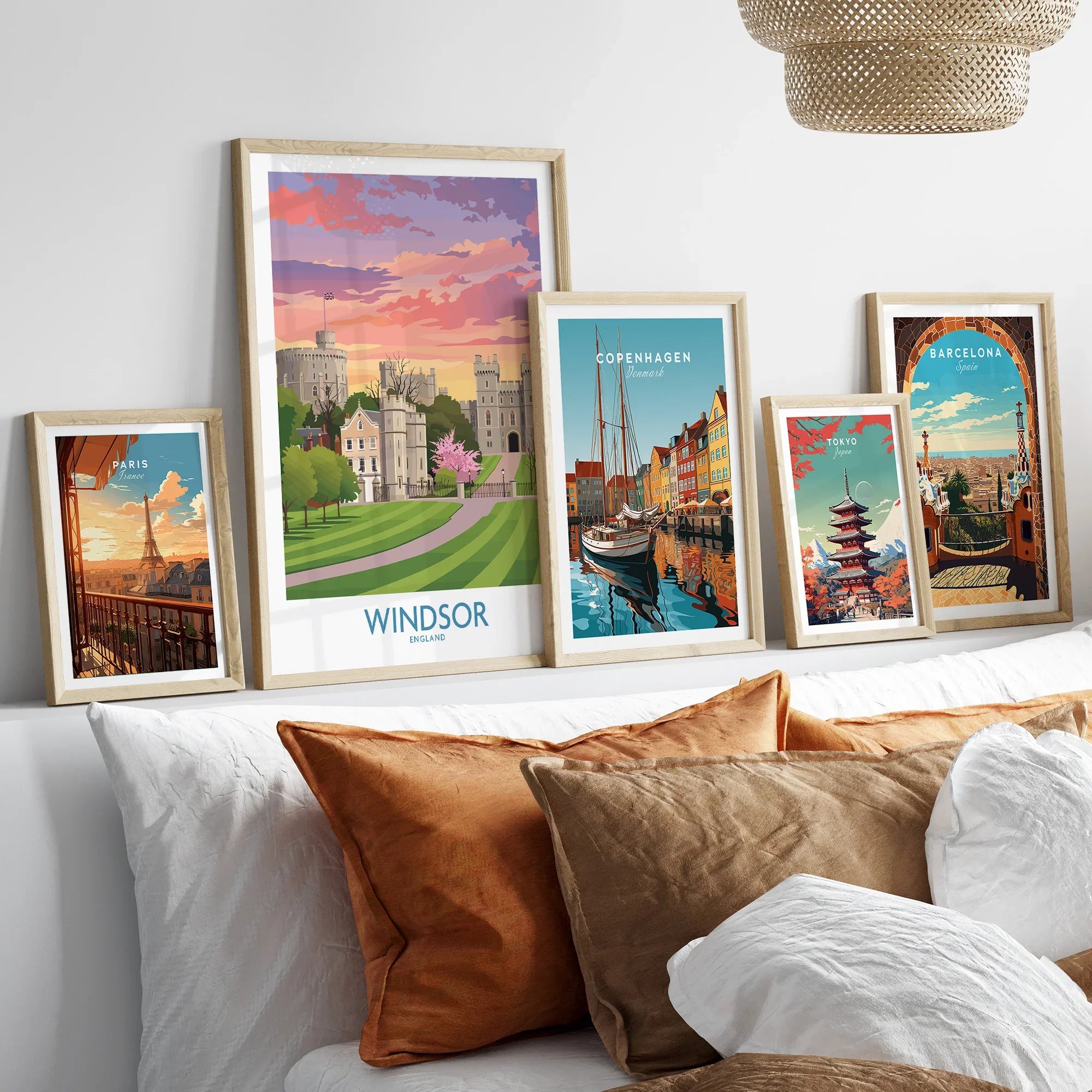 Framed travel posters of Windsor, Paris, Copenhagen, Tokyo, and Barcelona above a bed