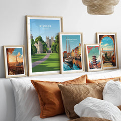 Framed travel posters of Windsor, Paris, Copenhagen, Tokyo, and Barcelona above a bed