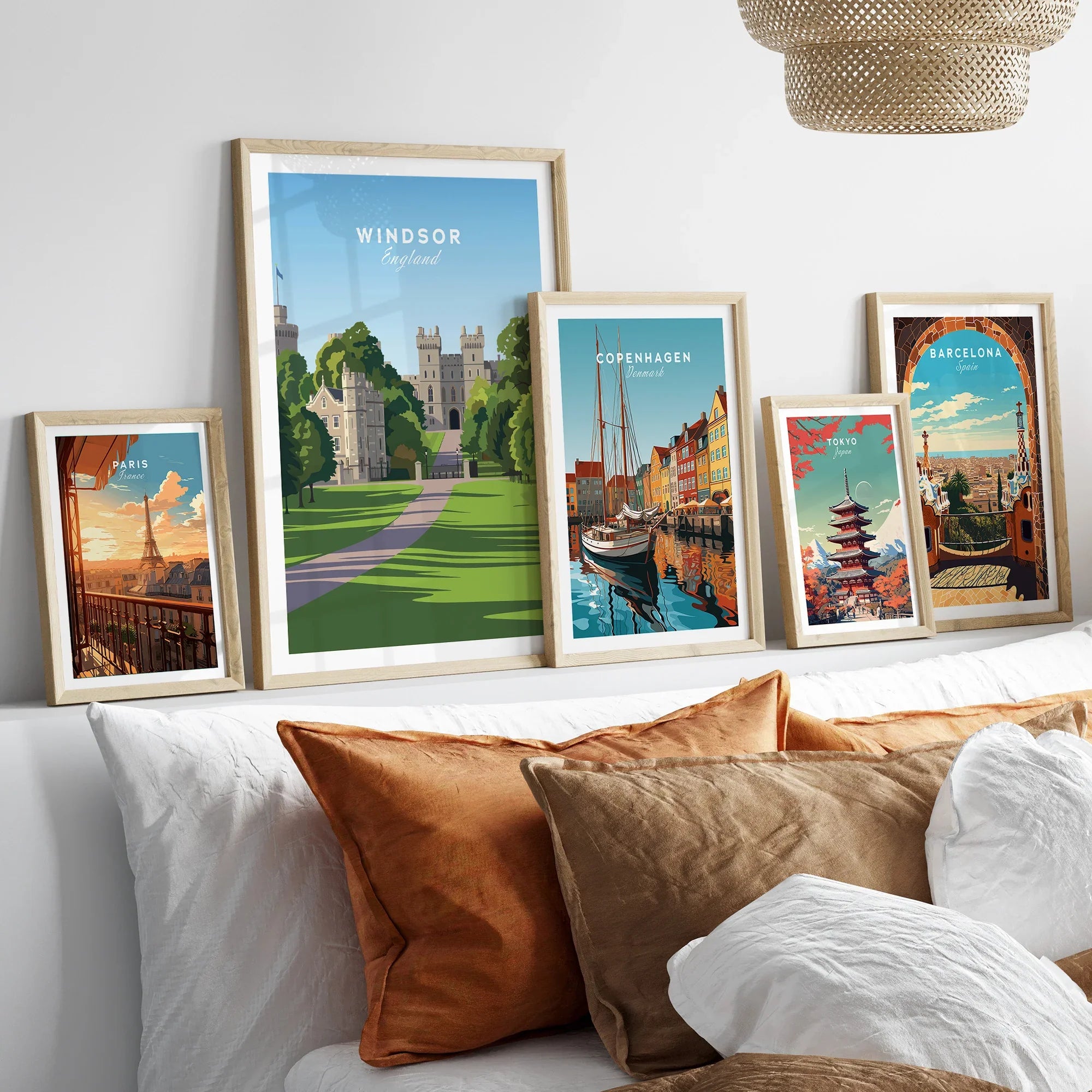 Framed travel posters of Windsor, Paris, Copenhagen, Tokyo, and Barcelona above a bed