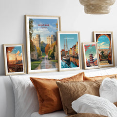 Set of five framed travel posters above bed, featuring Windsor, Paris, Copenhagen, Tokyo, Barcelona.