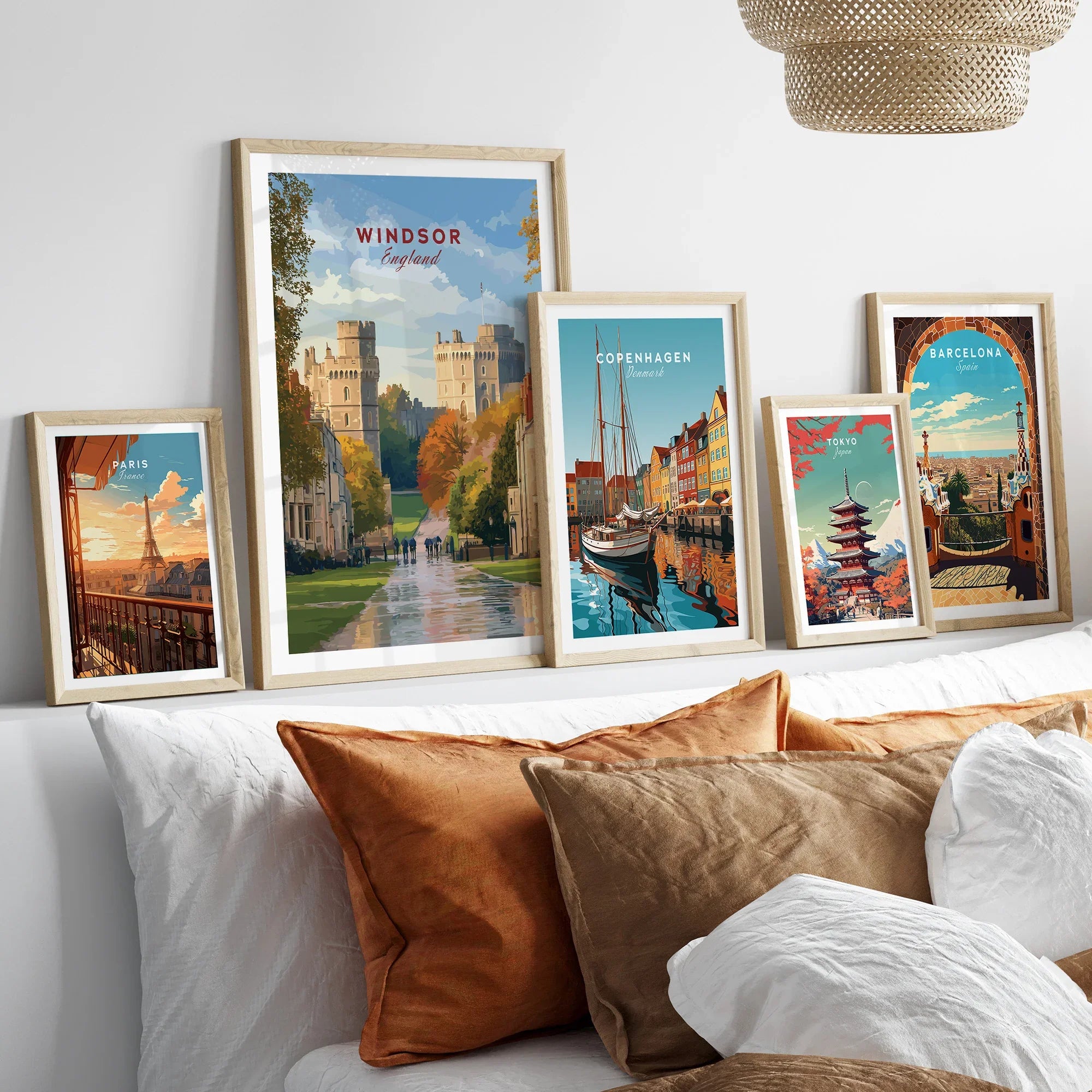 Set of five framed travel posters above bed, featuring Windsor, Paris, Copenhagen, Tokyo, Barcelona.