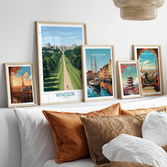 Five framed travel posters featuring Windsor, Paris, Copenhagen, Tokyo, and Barcelona above a bed.