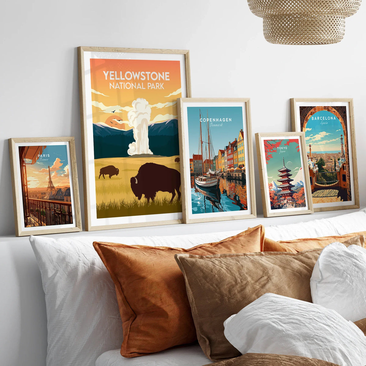 Set of five framed travel posters above bed, including Yellowstone, Paris, and Tokyo art prints