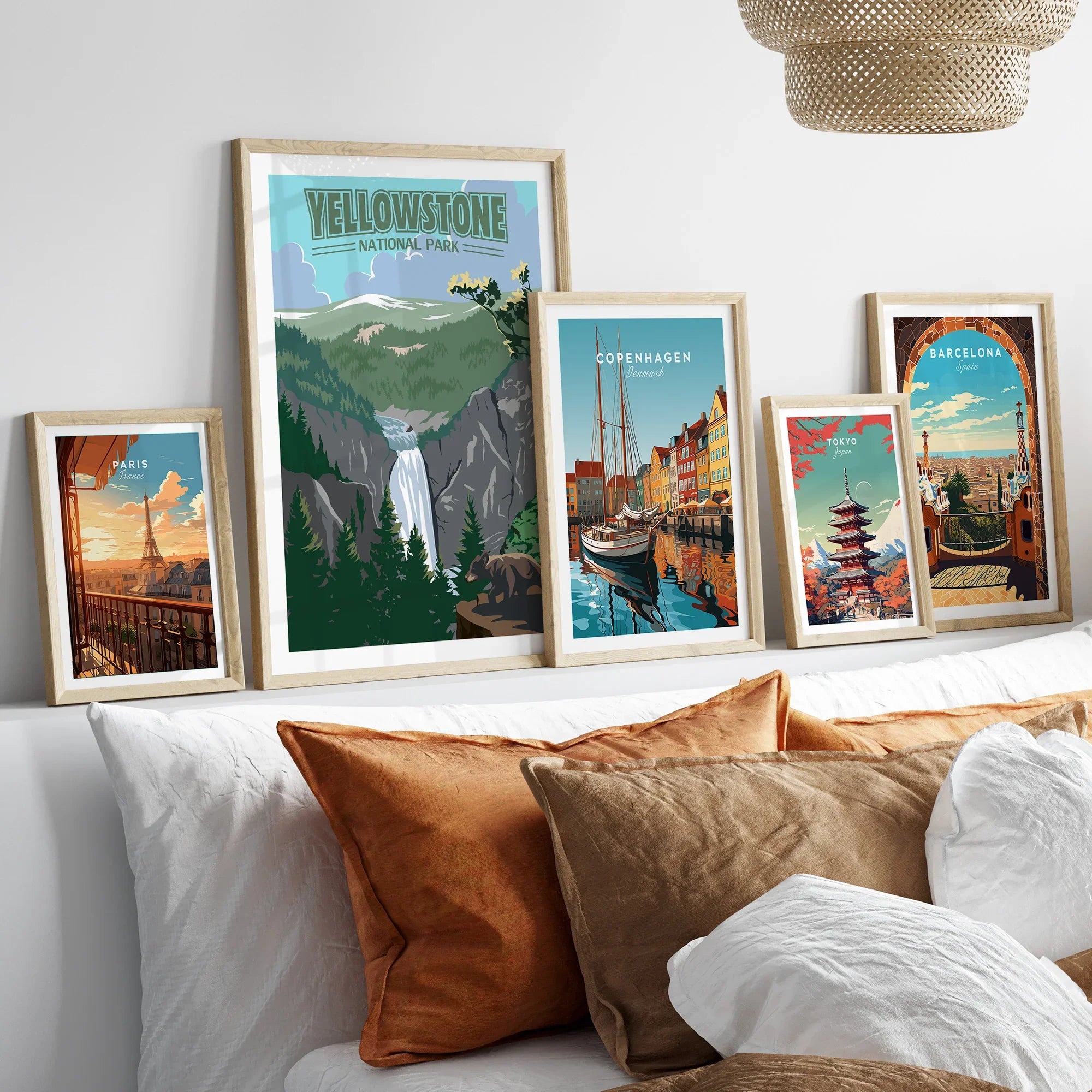 Framed travel posters of Yellowstone, Paris, Copenhagen, Tokyo, and Barcelona above a bed