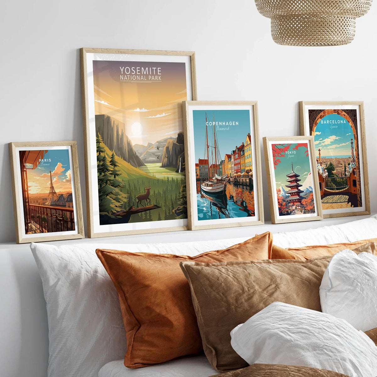 Framed travel posters of Yosemite, Paris, Copenhagen, Tokyo, and Barcelona above a bed
