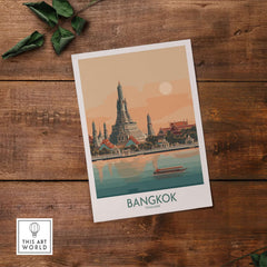 Bangkok Poster Thailand Temple of Dawn - Historic Thai Landmark Print displayed on a wooden table with green leaves.