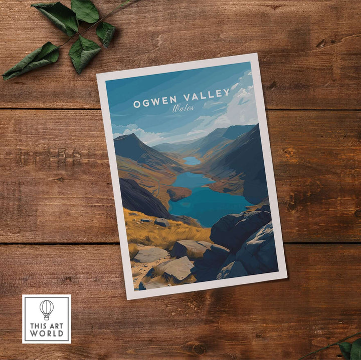 Ogwen Valley print showcasing Wales' mountain lakes and landscape, framed on wooden table.