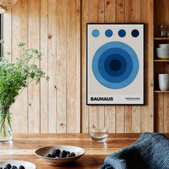 Bauhaus Exhibition Prints - Abstract Blue Circles Poster Geometric Design displayed in a cozy wooden interior.