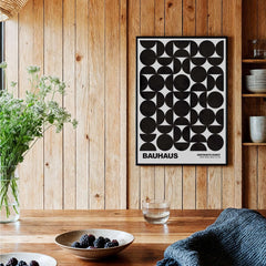 Bauhaus Exhibition Prints - Geometric Circle Shapes Art Print Black White Pattern displayed on a wooden wall with plants and berries.