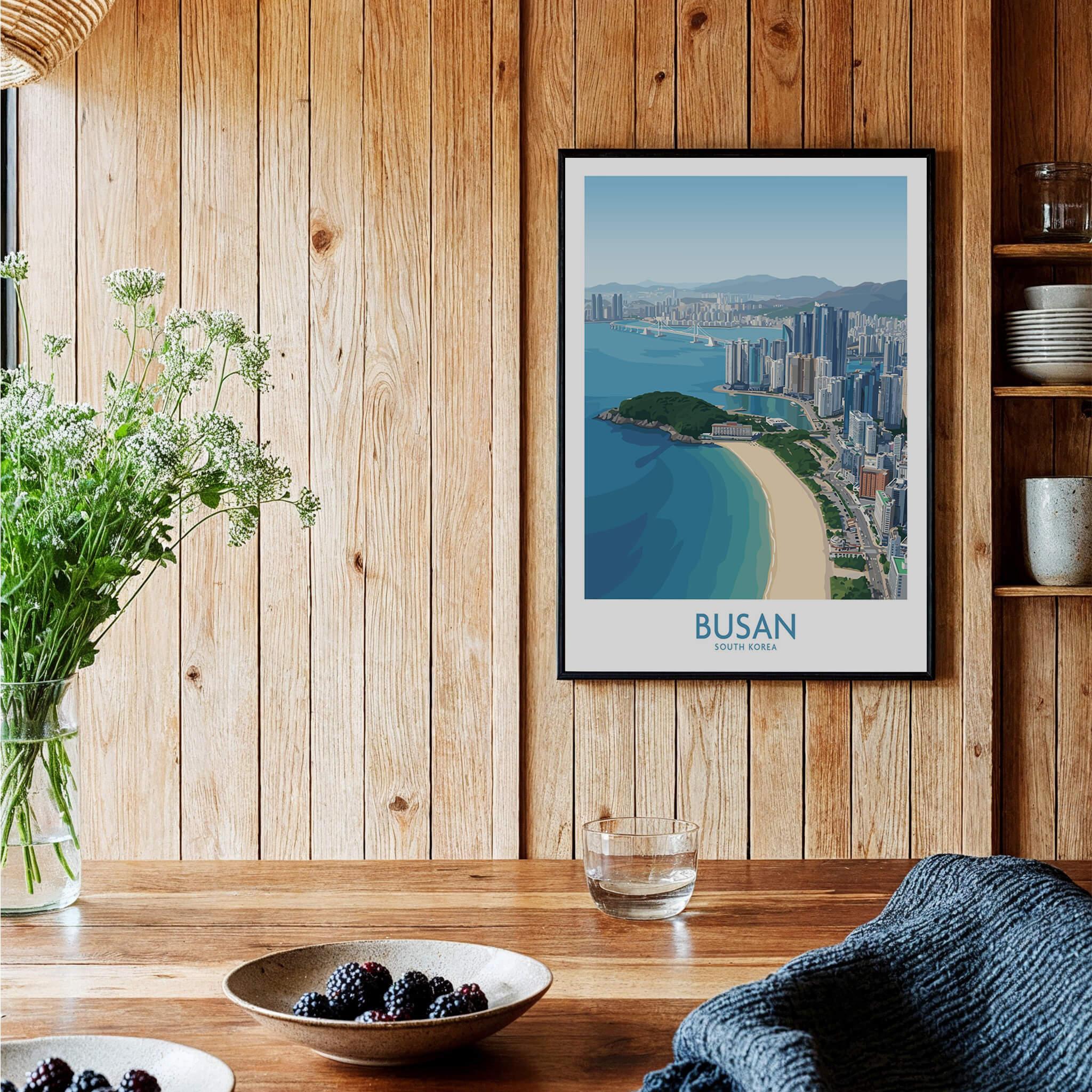 Framed Busan travel poster art print on wooden kitchen wall with beach and city skyline design