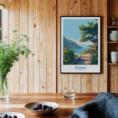Framed Busan travel poster with scenic coastal landscape art on wooden kitchen wall