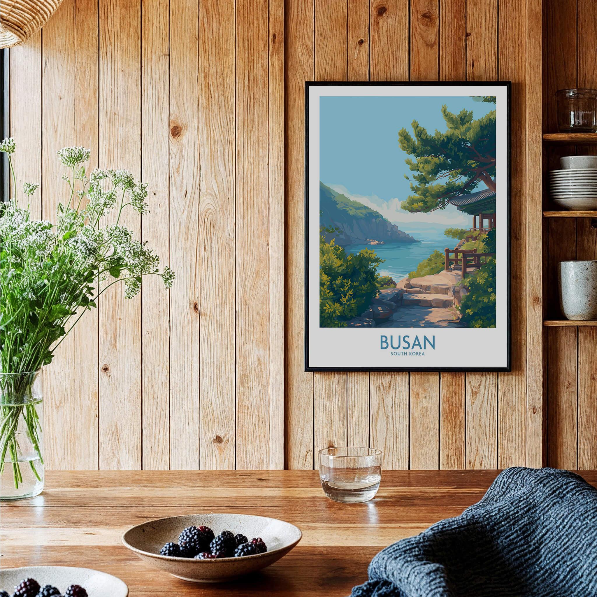 Framed Busan travel poster with scenic coastal landscape art on wooden kitchen wall