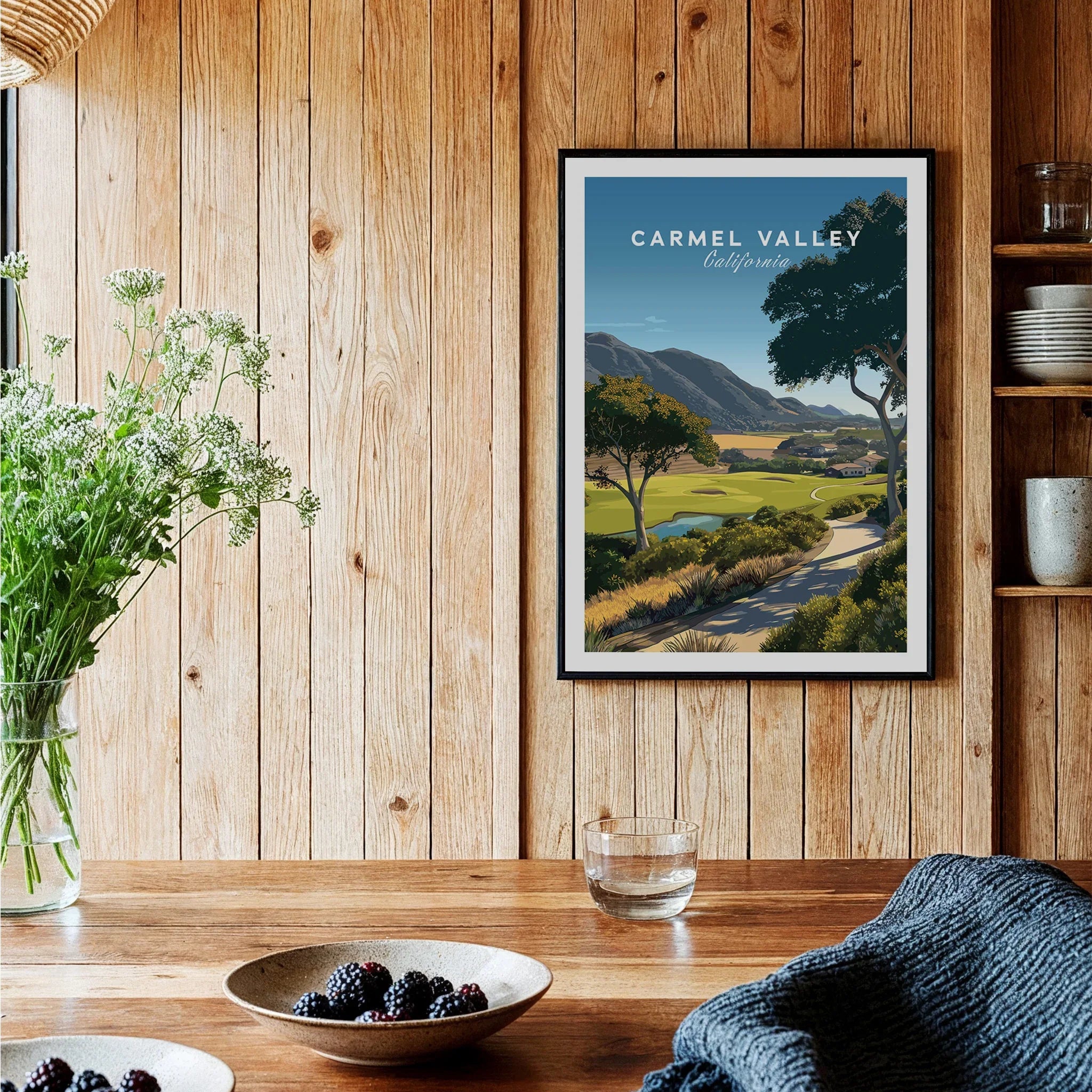 Carmel Valley travel poster art print in black frame hanging in rustic kitchen setting
