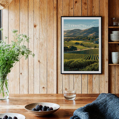 Carmel Valley travel poster art print in black frame on rustic wood kitchen wall