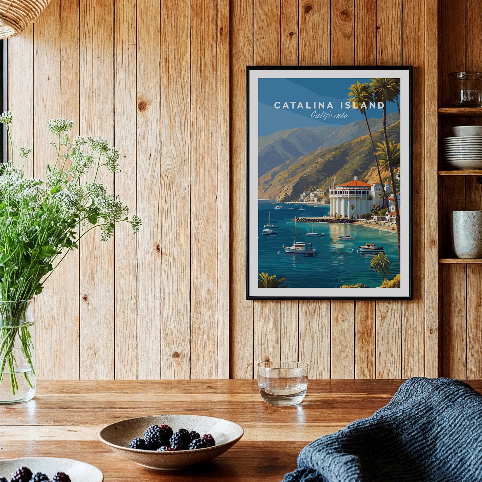 Framed Catalina Island travel poster art print on rustic wood kitchen wall with boats and coastline