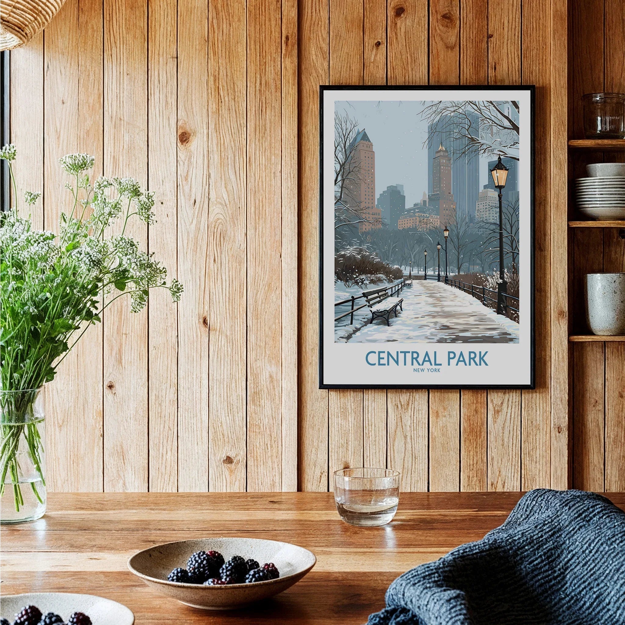 Central Park art print with winter city skyline in black frame, hanging in a rustic kitchen.