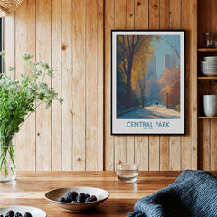 Central Park art print in black frame hangs on wooden kitchen wall above rustic table