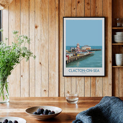 Clacton-on-Sea England Wall Art – British Seaside Decor displayed on wooden wall with plants and table.