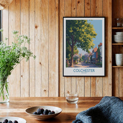 Colchester travel art print in black frame on rustic wood kitchen wall, with fresh flowers and berries.