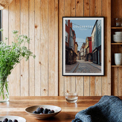 Colchester travel poster wall art in a rustic kitchen with wooden wall and dining table