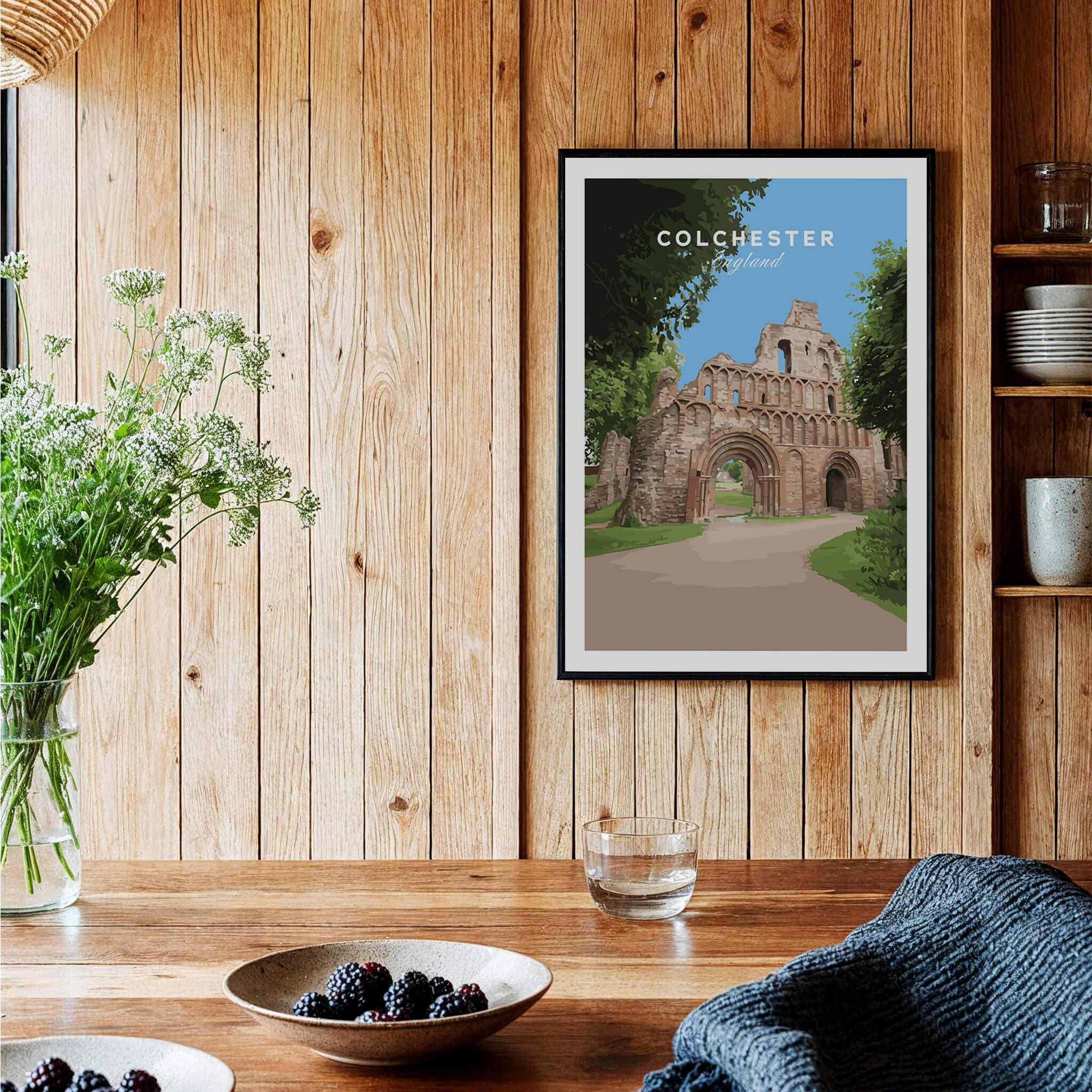 Colchester travel poster art print in black frame, displayed in rustic kitchen decor setting