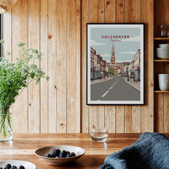 Colchester cityscape art print in black frame hanging on a wooden kitchen wall, modern decor