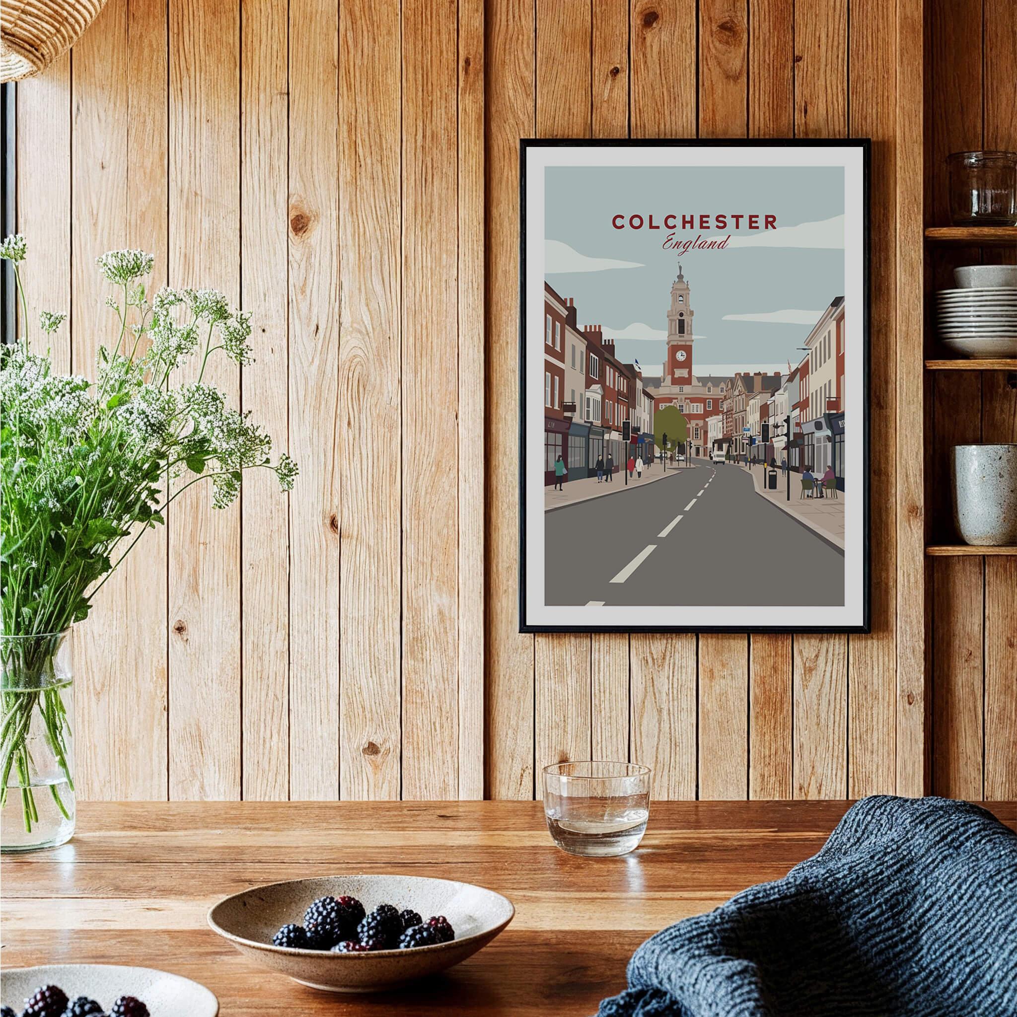 Colchester cityscape art print in black frame hanging on a wooden kitchen wall, modern decor