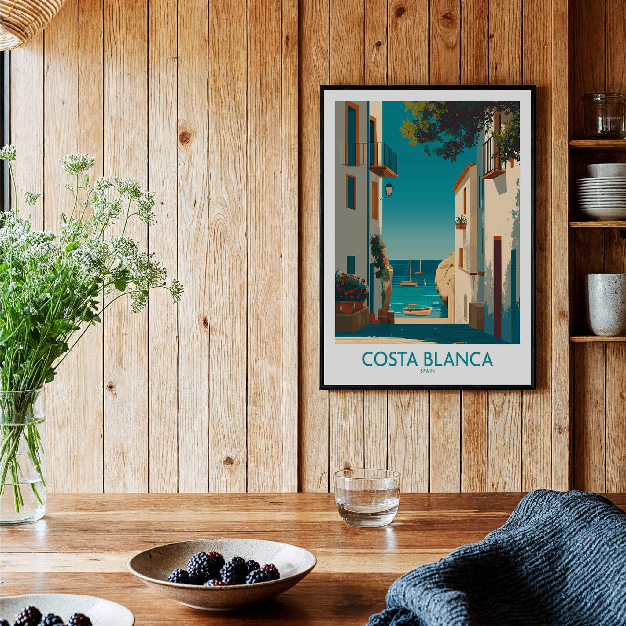 Costa Blanca Spain Wall Art Print - Spanish Village Artwork framed on a wooden wall with plants and table decor.