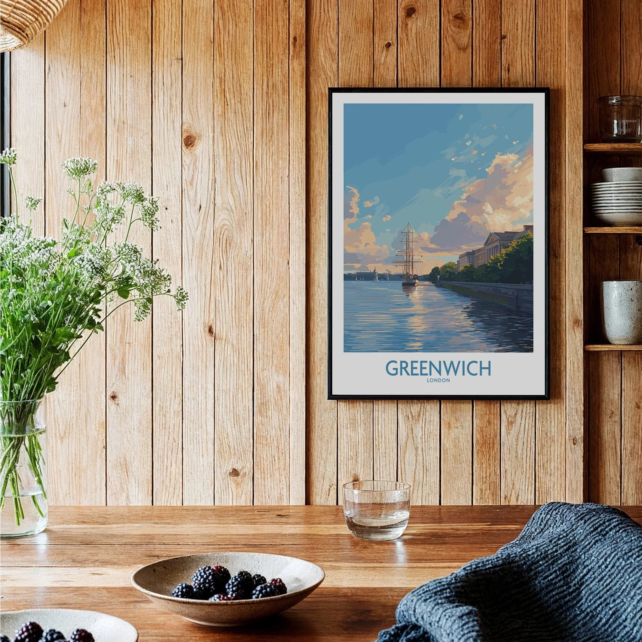 Greenwich travel poster in black frame displayed in cozy wooden kitchen setting