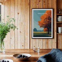 Framed Greenwich London travel poster with autumn trees on wood wall in cozy kitchen.