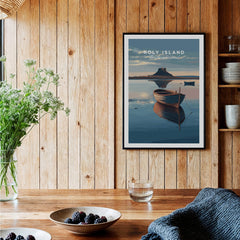 Holy Island Northumberland Wall Art Print | Serene Boat Scene Travel Poster displayed against wooden wall with decorative items.
