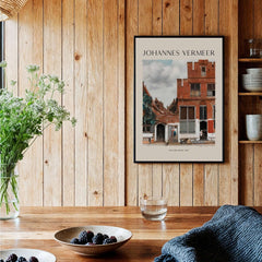 Johannes Vermeer The Little Street 1657 Delft Scene Dutch Golden Age Art Print displayed in a rustic wooden interior.