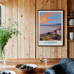 Llandudno travel art print with coastal tram scene in black frame, displayed in rustic kitchen