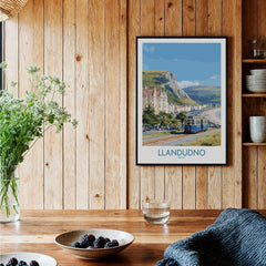 Framed Llandudno travel poster on wooden kitchen wall, rustic decor, berries on table