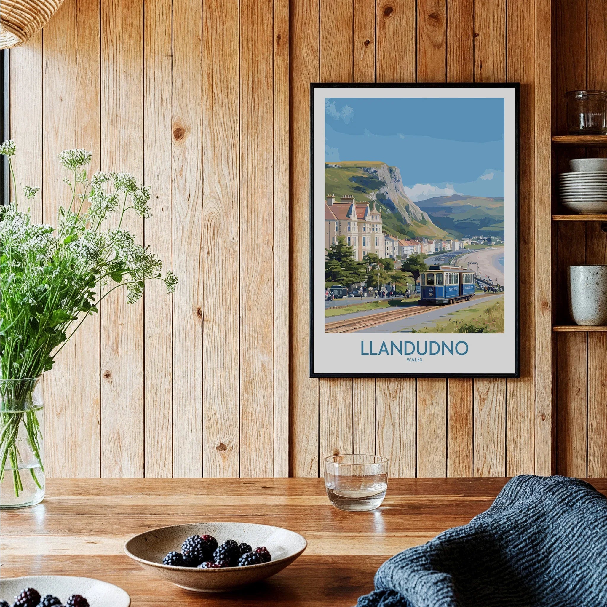 Framed Llandudno travel poster on wooden kitchen wall, rustic decor, berries on table