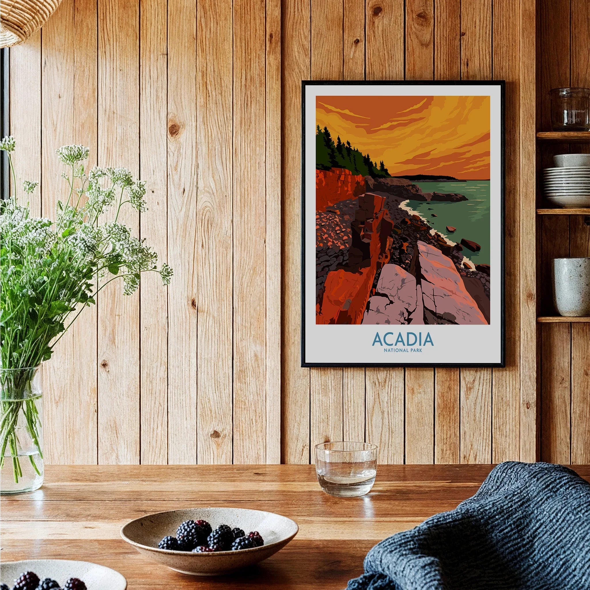 Acadia National Park poster framed on rustic kitchen wall with wood paneling and bowls of berries.