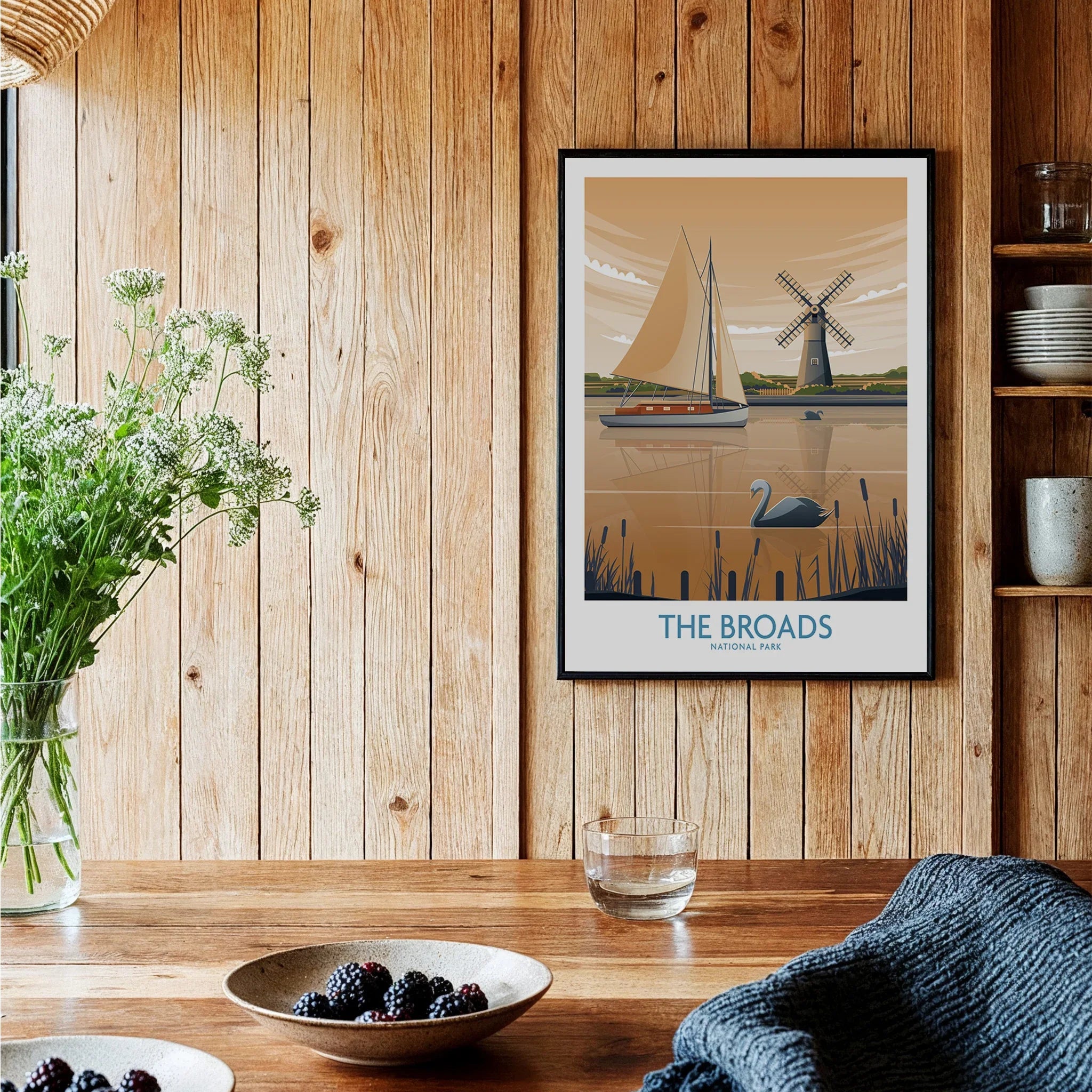 Framed The Broads National Park travel poster in a rustic kitchen with wooden walls