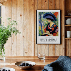 Matisse Art Prints - Woman with Blue Hat Garden Poster displayed in a cozy interior with wooden elements.