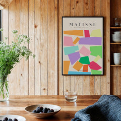 Matisse Art Prints - Colorful Geometric Shapes Abstract Print displayed on a wooden wall, adding vibrant decor to a cozy setting.