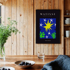 Matisse Art Prints - Stars Leaves Night Sky Abstract Print displayed on a wooden wall with greenery and decor.