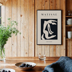 Matisse Art Prints - Abstract Organic Figure Cut Out Print displayed on a wooden wall with plants and bowls.
